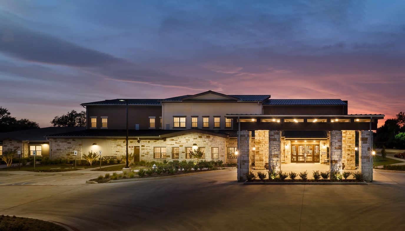 Exterior view of Spring Cypress Senior Living at sunset