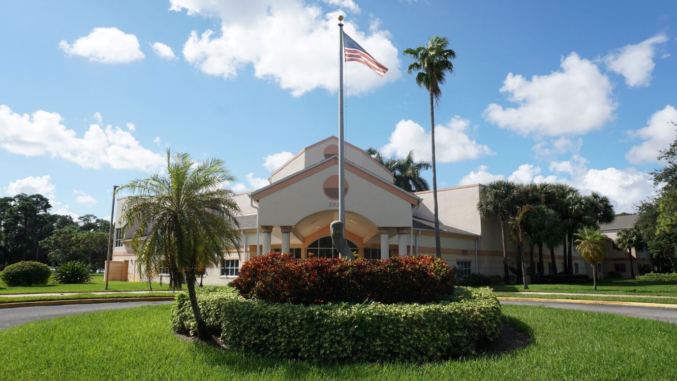Exterior view of Argo Senior Living with flag and landscaping