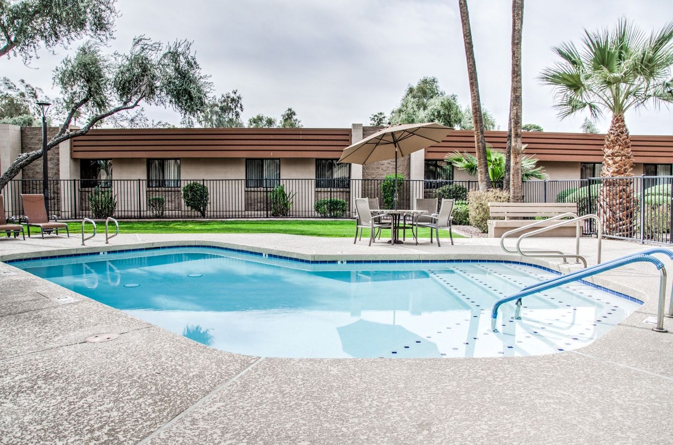 A swimming pool area with seating and landscaping