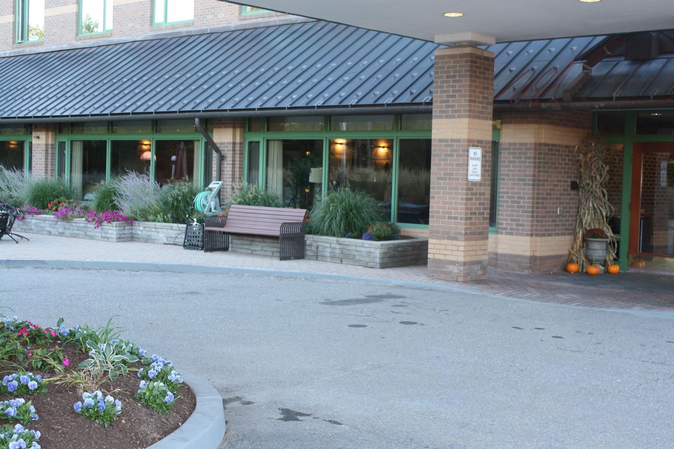 Entrance of Eisenberg Assisted Living Residence with flowers and seating