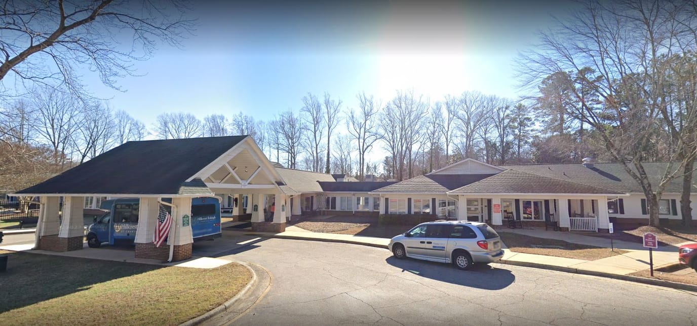 Exterior view of Hillcrest Raleigh facility with vehicles