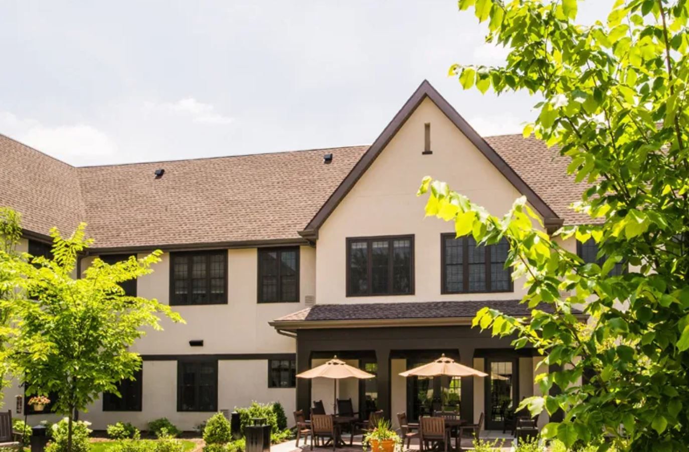Exterior view of Lodge Lane Assisted Living with patio seating