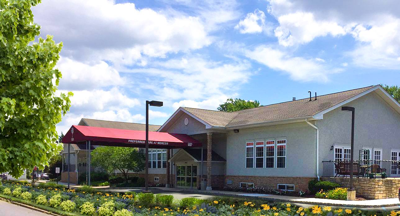 Exterior view of Preferred Care at Mercer facility with flowers