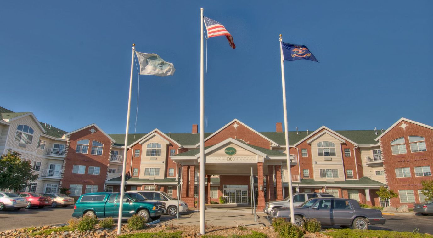 Building exterior of Touchmark on West Century with flags
