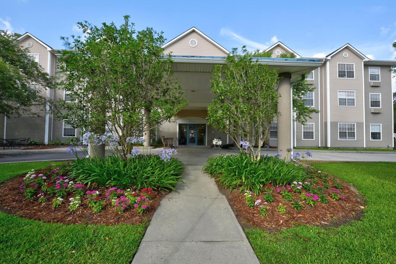 Entrance to Ville Ste Marie Senior Living with landscaped pathway