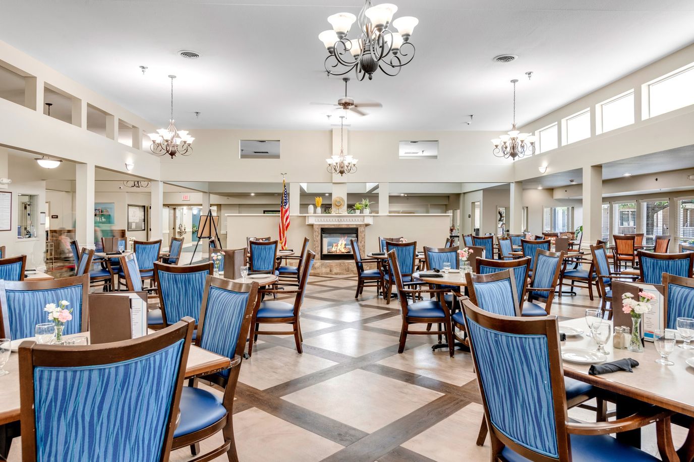 Bright dining area with blue chairs and flowers on tables