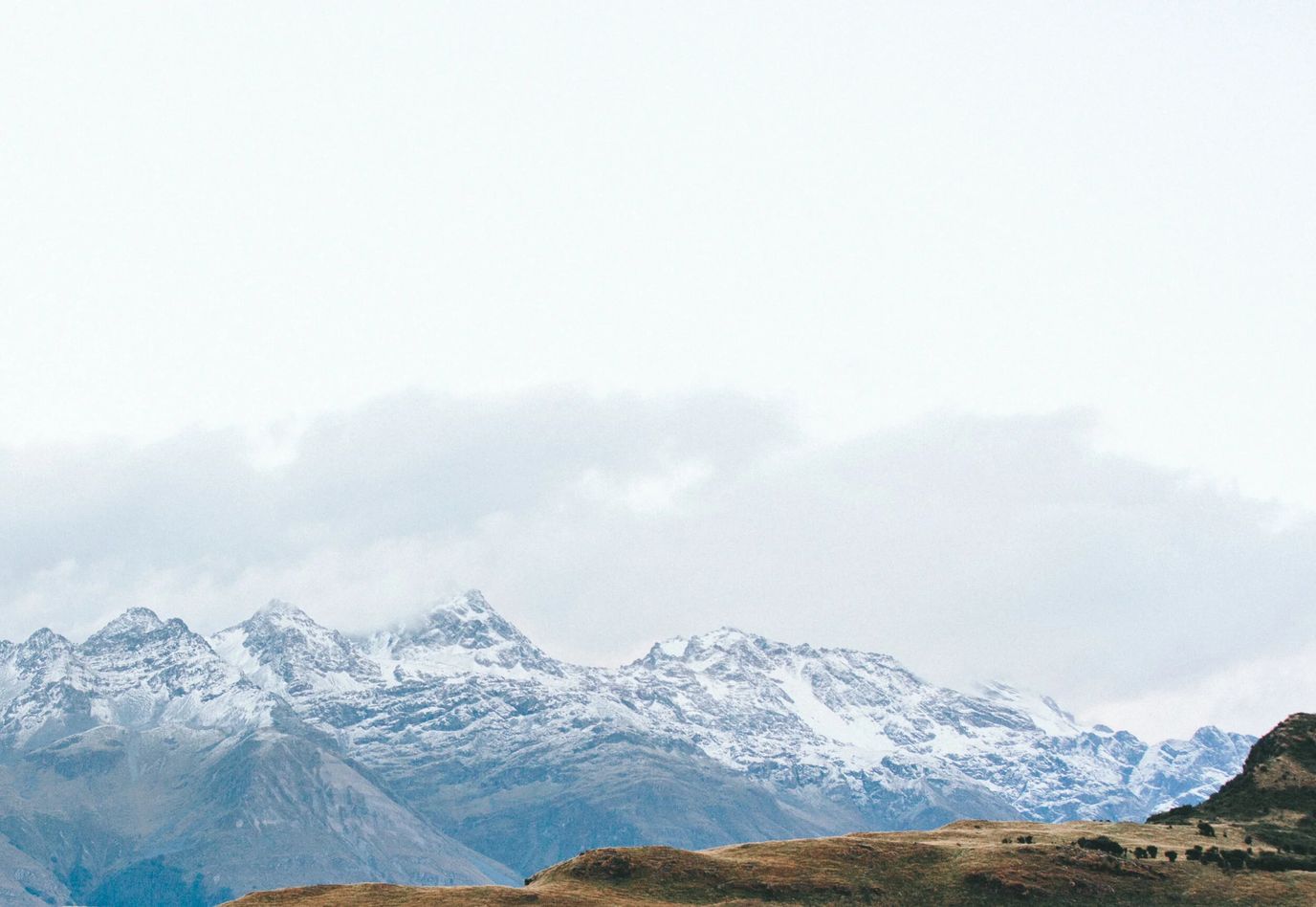 Snow-capped mountains under a cloudy sky