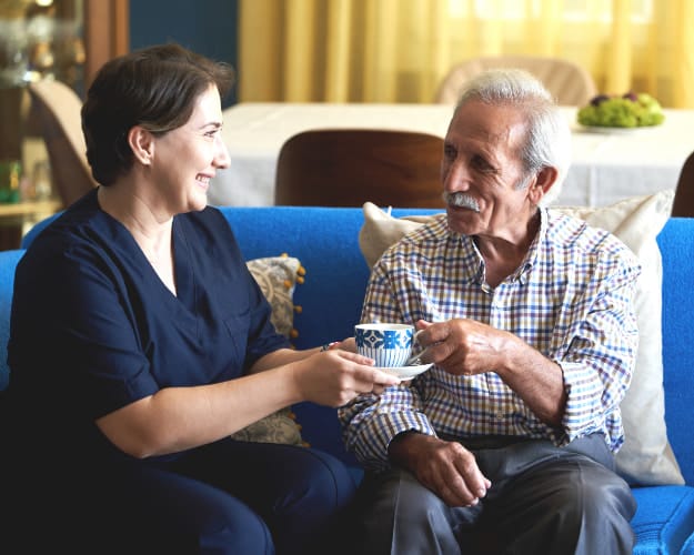 Caregiver sharing tea with an elderly resident