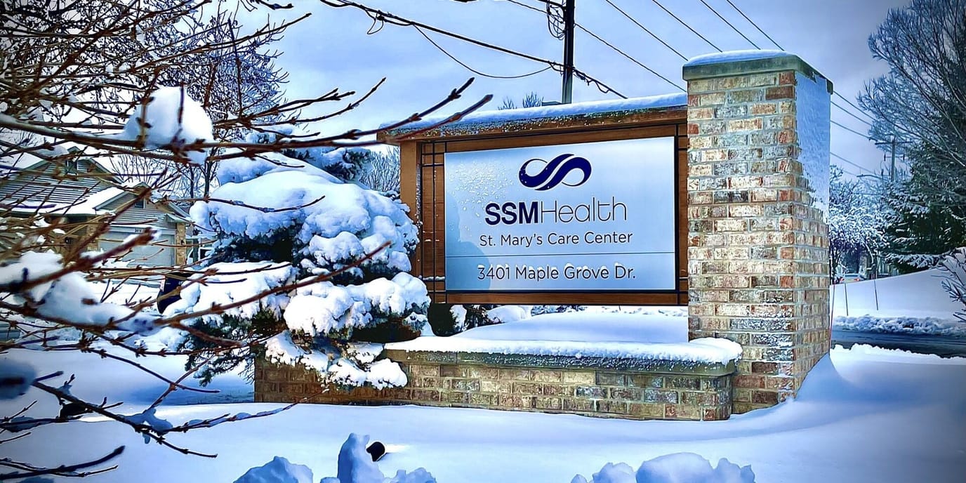 Snow-covered facility sign for SSM Health St. Mary's Care Center