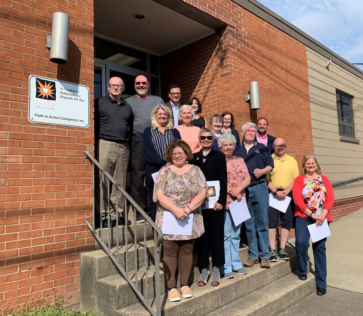 Group photo of staff and residents in front of the facility