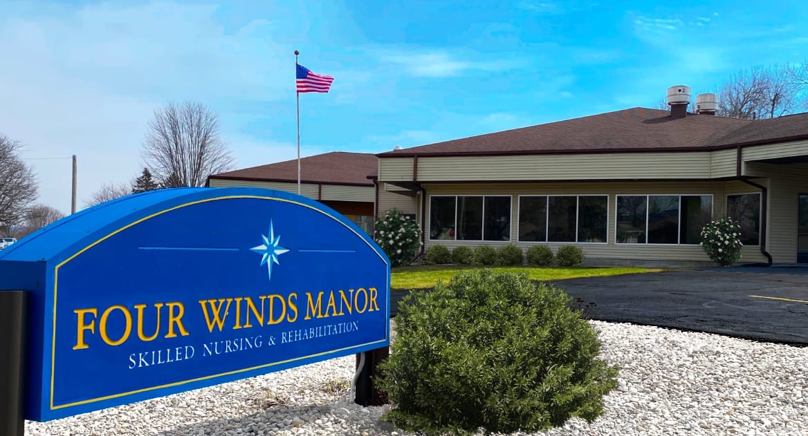 Exterior view of Four Winds Manor building and signage