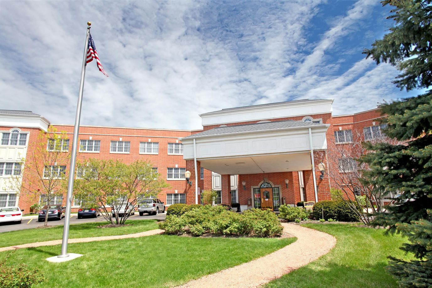 Building exterior of a senior living facility with landscaped grounds.