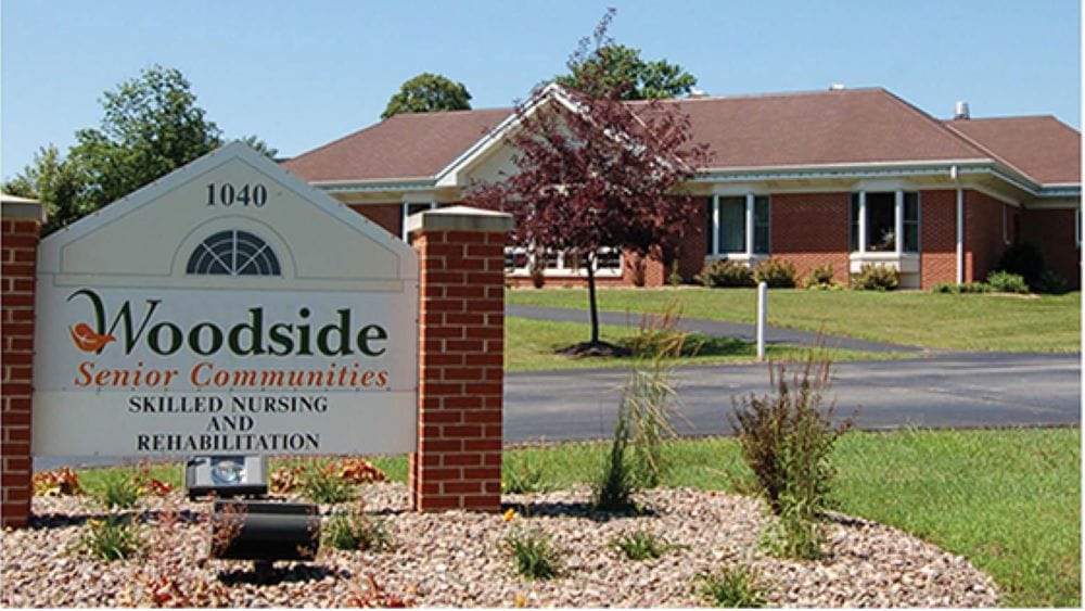 Exterior view of Woodside Senior Communities building and sign