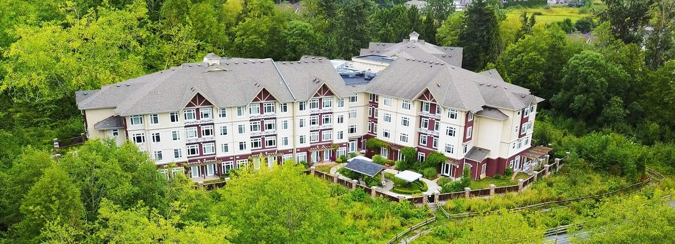 Aerial view of a senior living facility surrounded by greenery