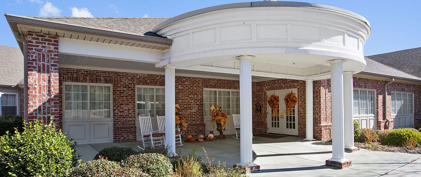 Exterior view of assisted living facility entrance decorated for fall