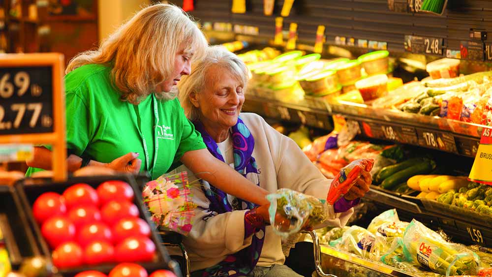 Resident shopping with staff assistance.