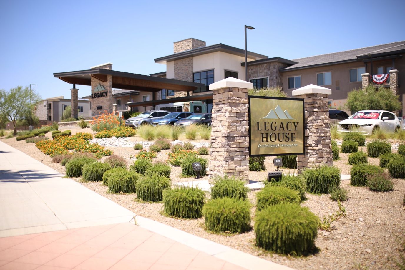 Exterior view of Legacy House with garden and sign
