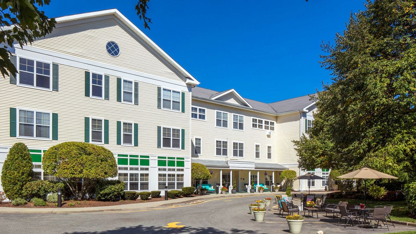 Exterior view of a senior living facility with outdoor seating