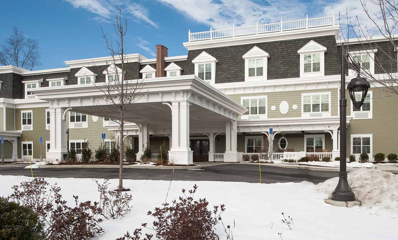 Exterior view of a senior living facility with snowy landscaping
