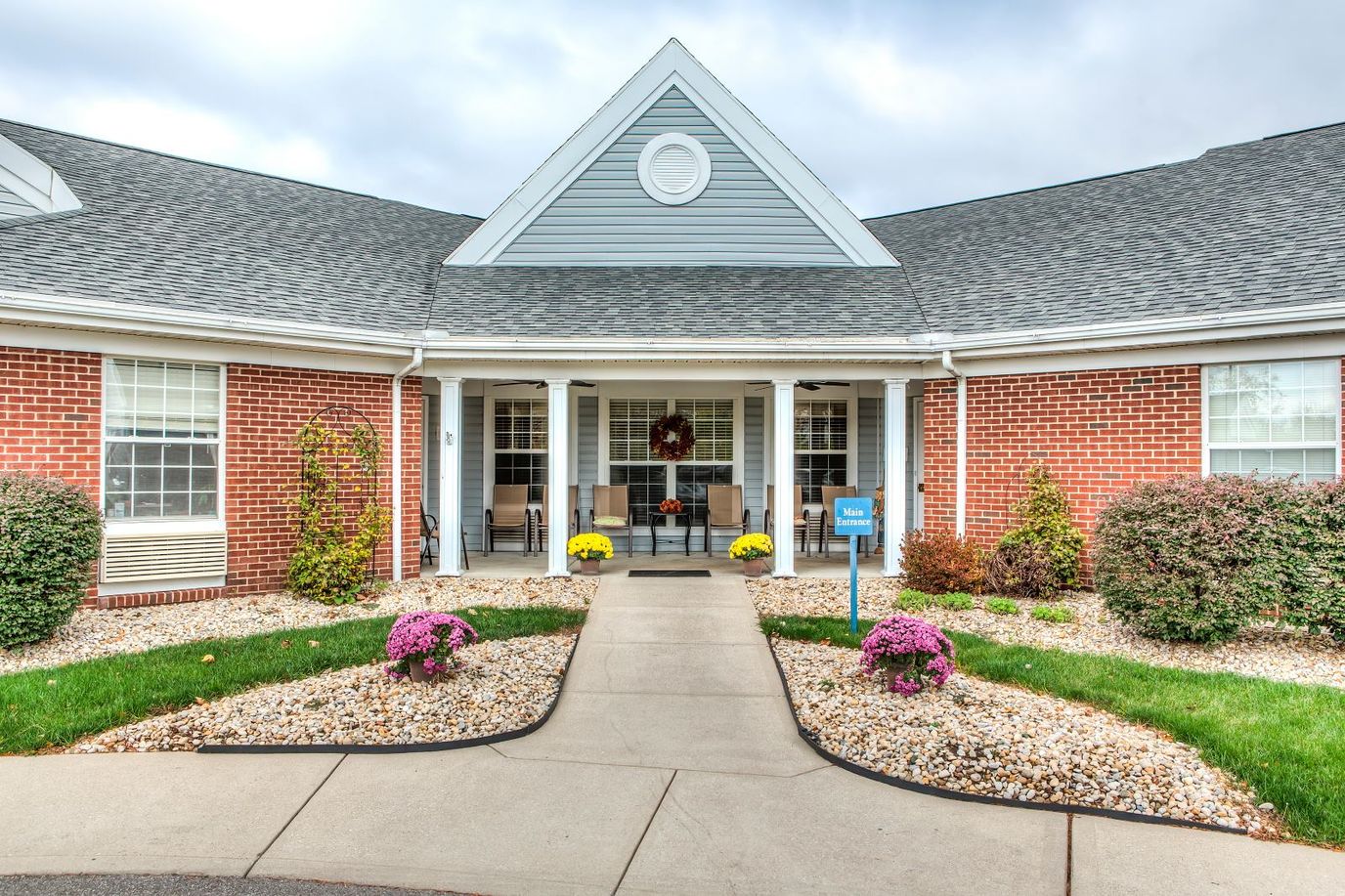 Front entrance of a senior living facility with flowers