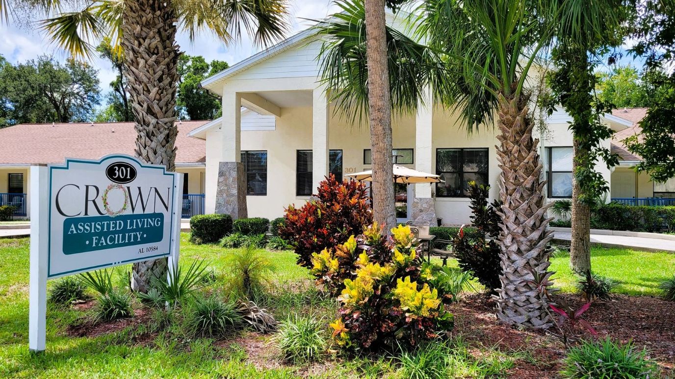 Exterior view of Crown Assisted Living facility with landscaping