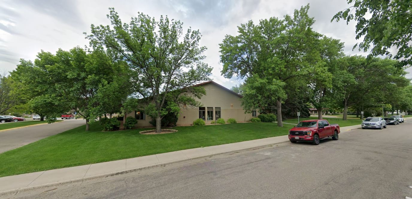 Exterior view of a senior living facility with landscaped lawn