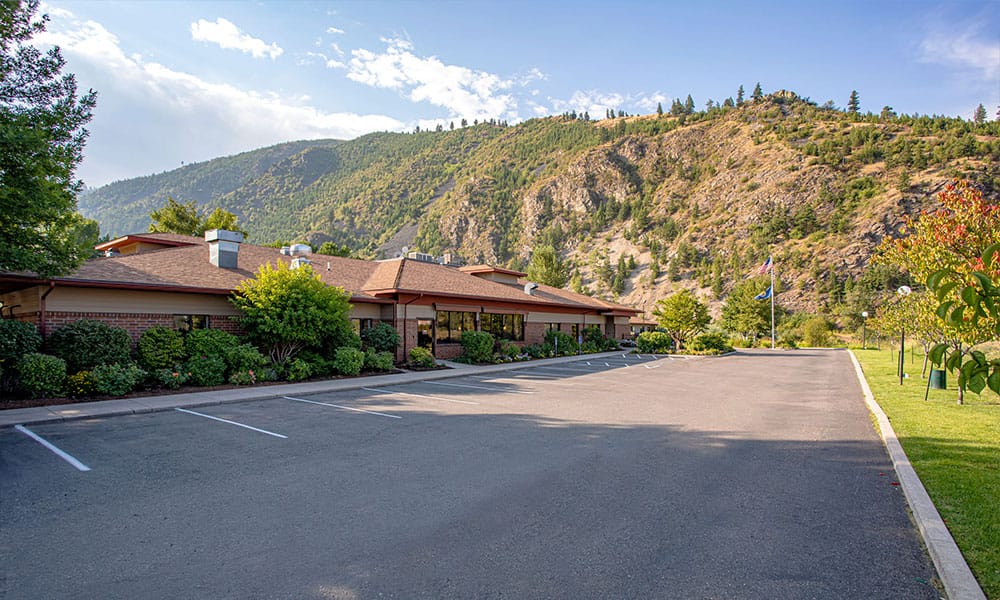 Exterior view of Riverside Nursing and Rehabilitation Center with mountains