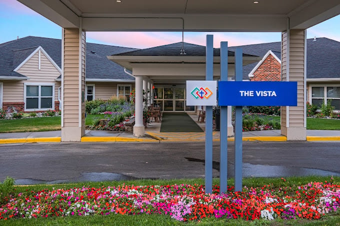 Entrance to The Vista facility with flower beds