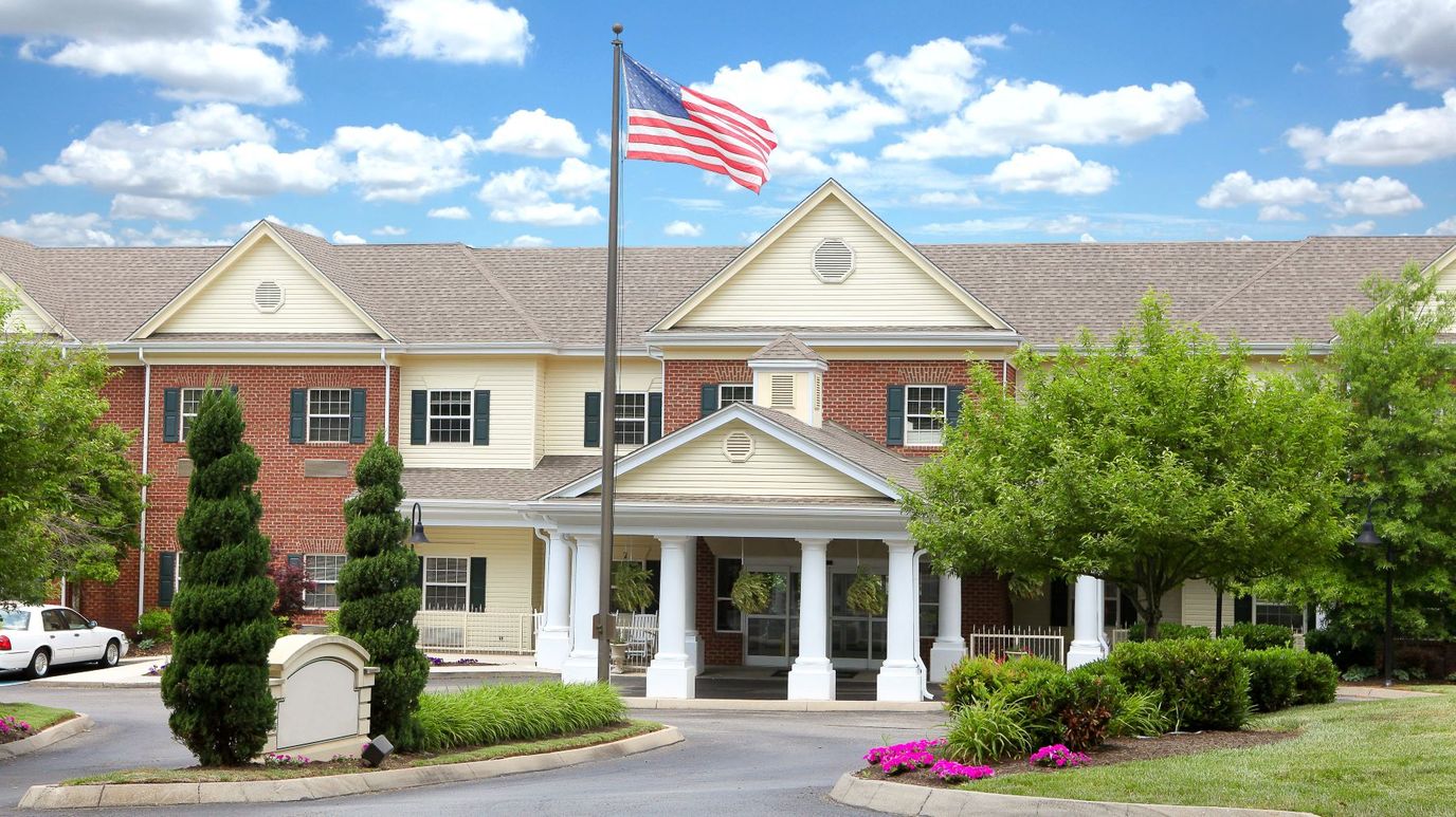 Exterior view of a senior living facility with landscaped entrance
