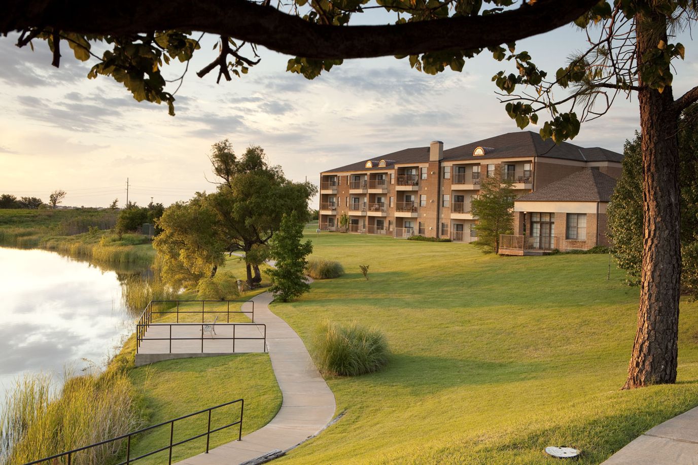 Exterior view of the facility by a lake at sunset