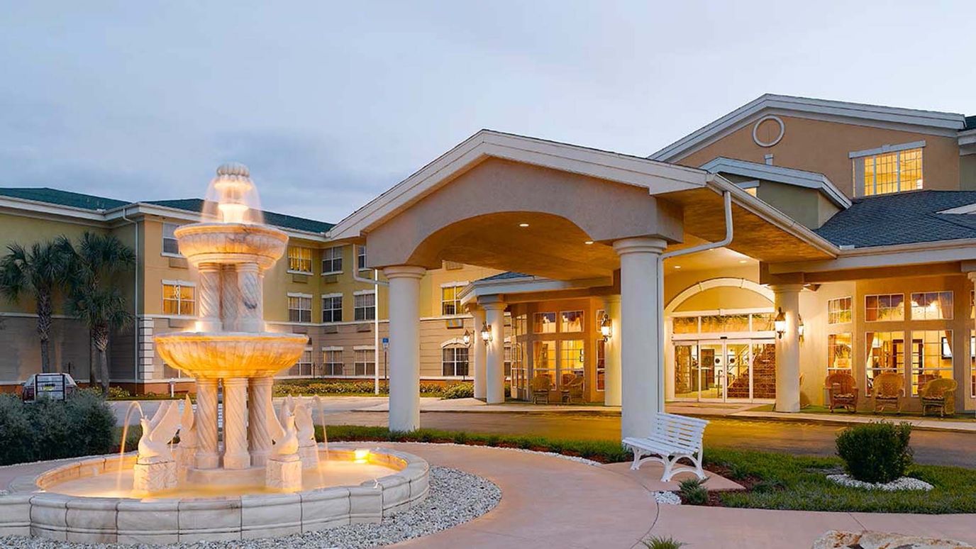 Exterior view of senior living facility with fountain
