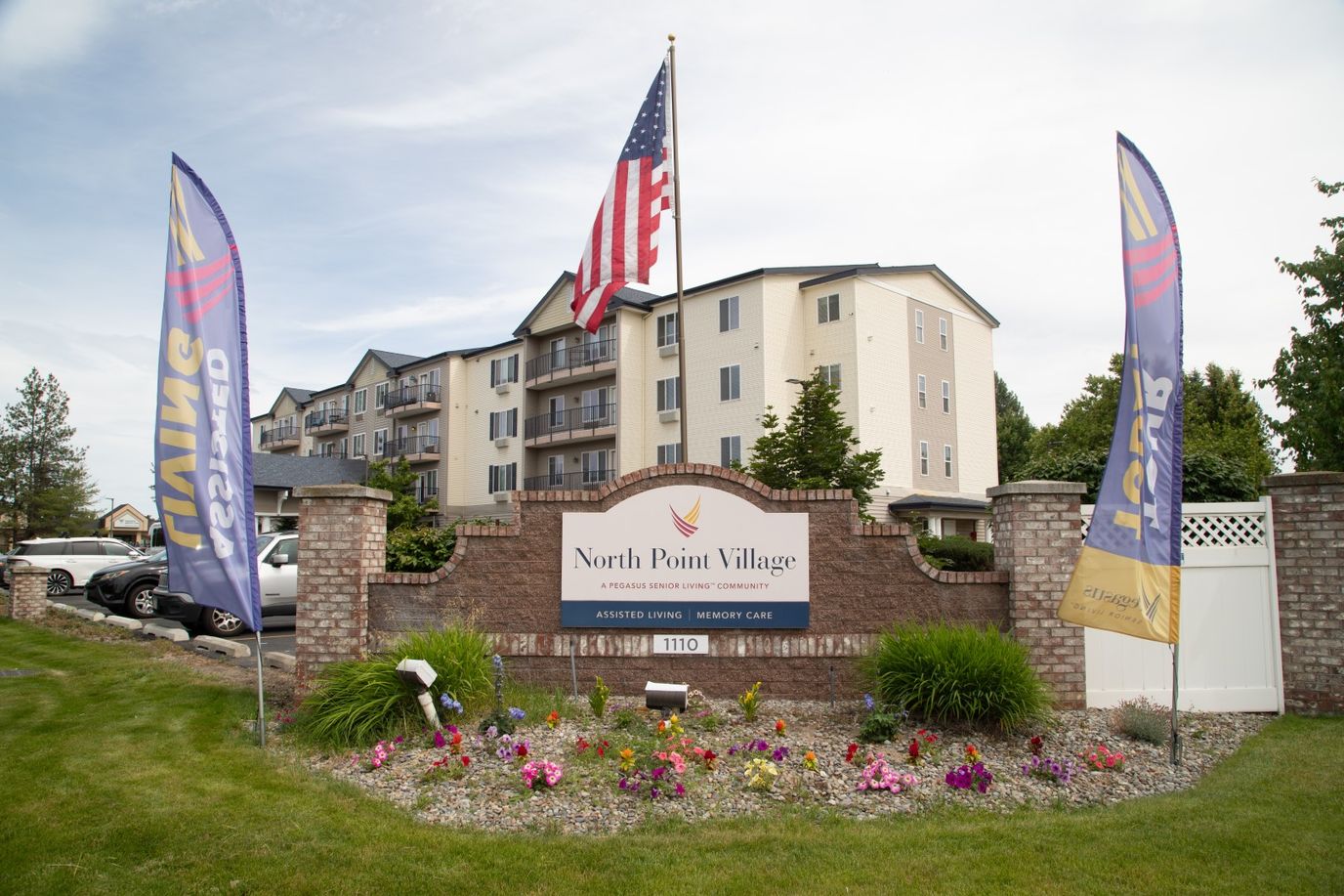 Front entrance of North Point Village with flowers and flags