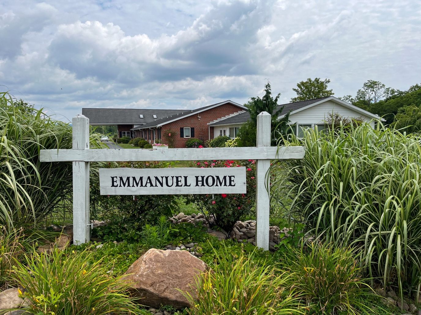 Exterior view of the Emmanuel Home sign with surrounding greenery