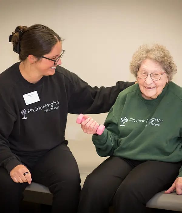 Staff assisting a resident with light exercise