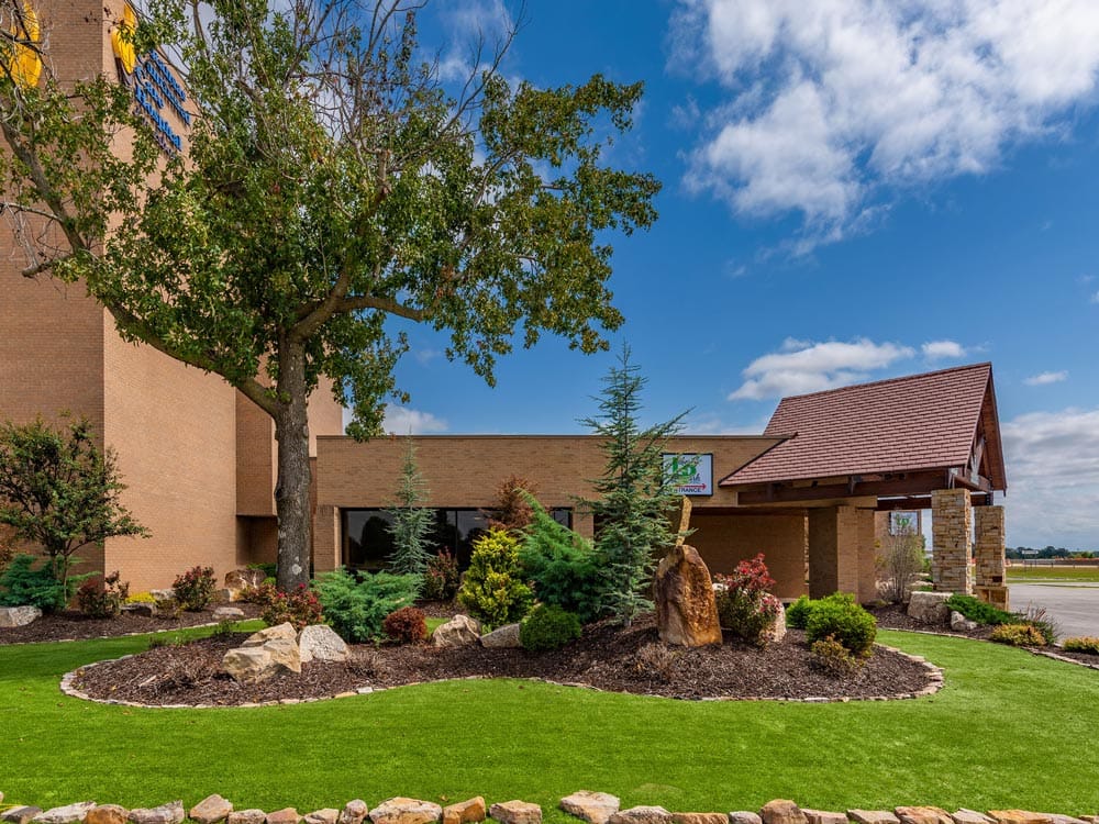 Liberty Park Senior Living of Jonesboro, assisted living in Jonesboro, AR — Landscaped entrance of a senior living facility with trees