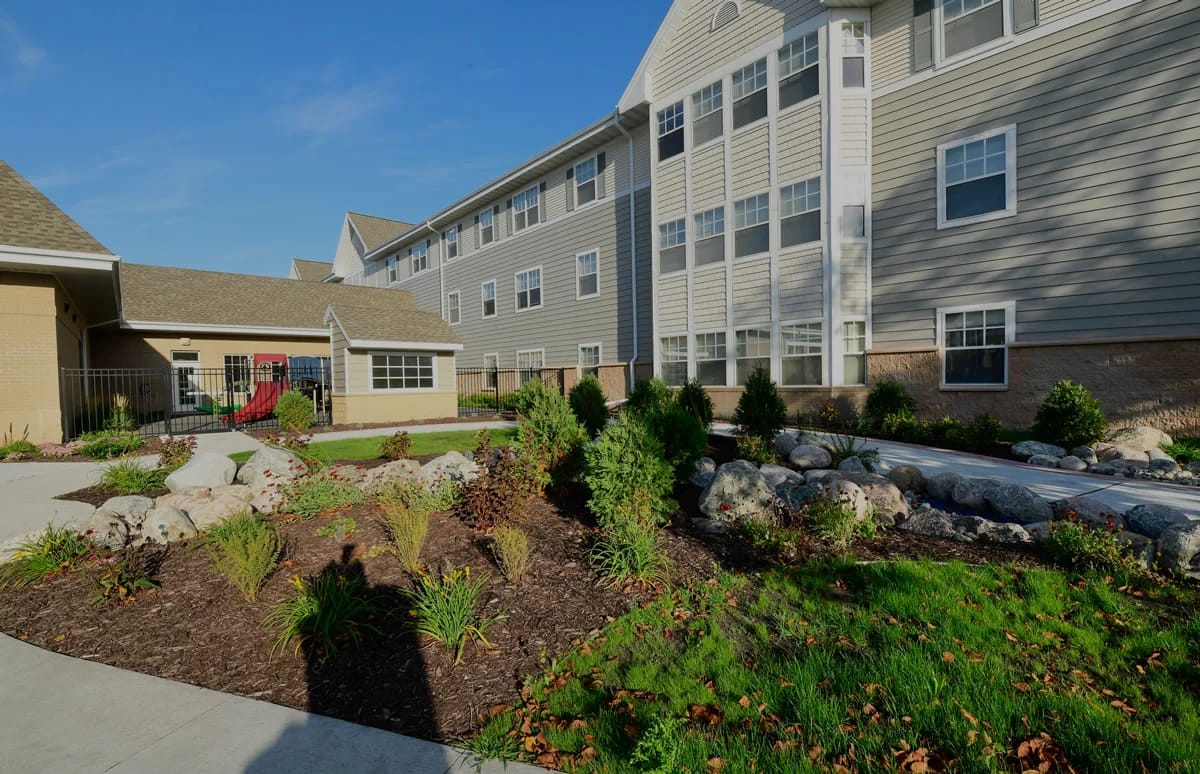 Exterior view of a senior living facility with landscaped garden