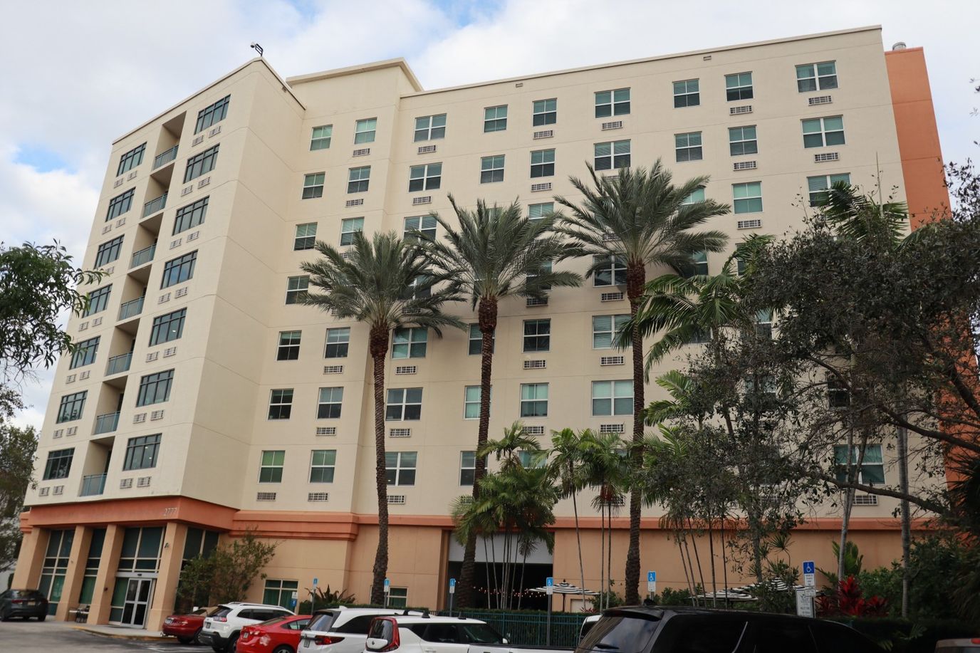 Exterior view of a senior living facility with palm trees