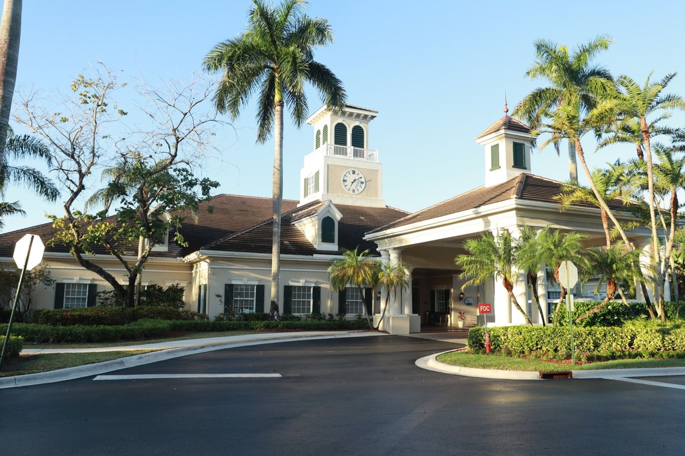 Exterior view of a senior living facility with palm trees.