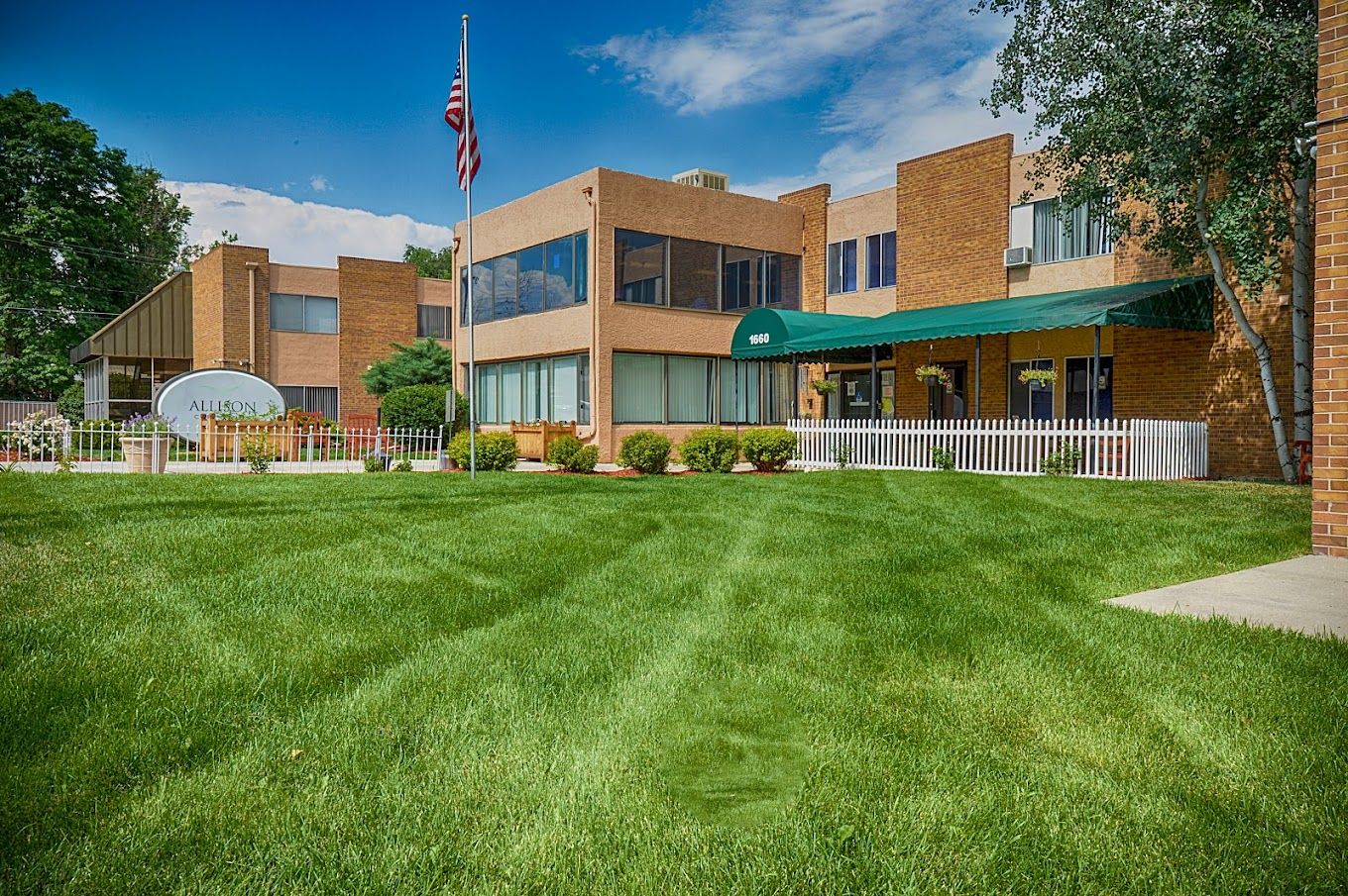 Exterior view of a senior living facility with green lawn