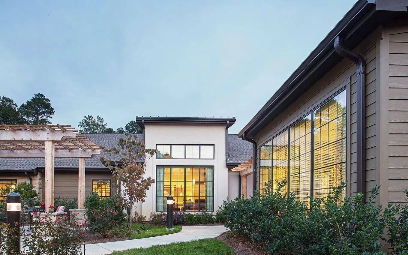 Exterior view of a senior living facility with gardens