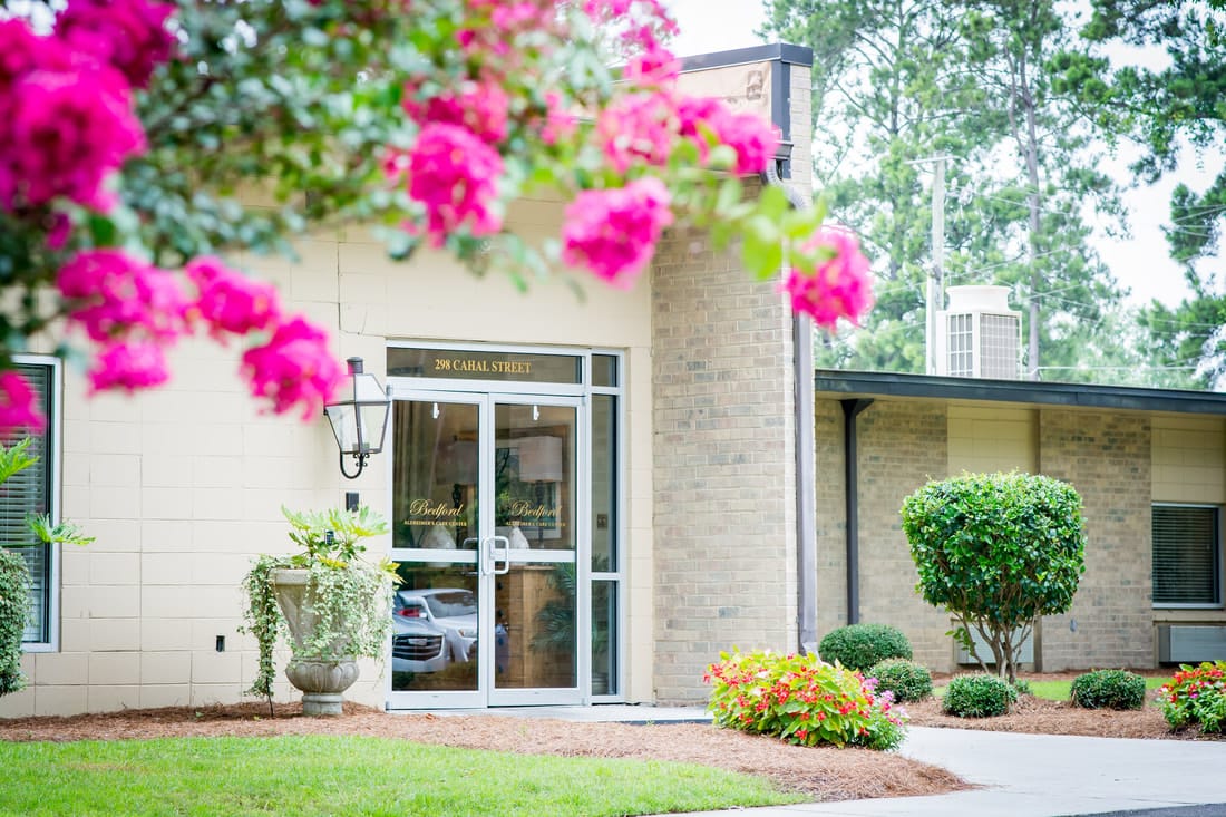 Exterior view of a senior living facility entrance with flowers