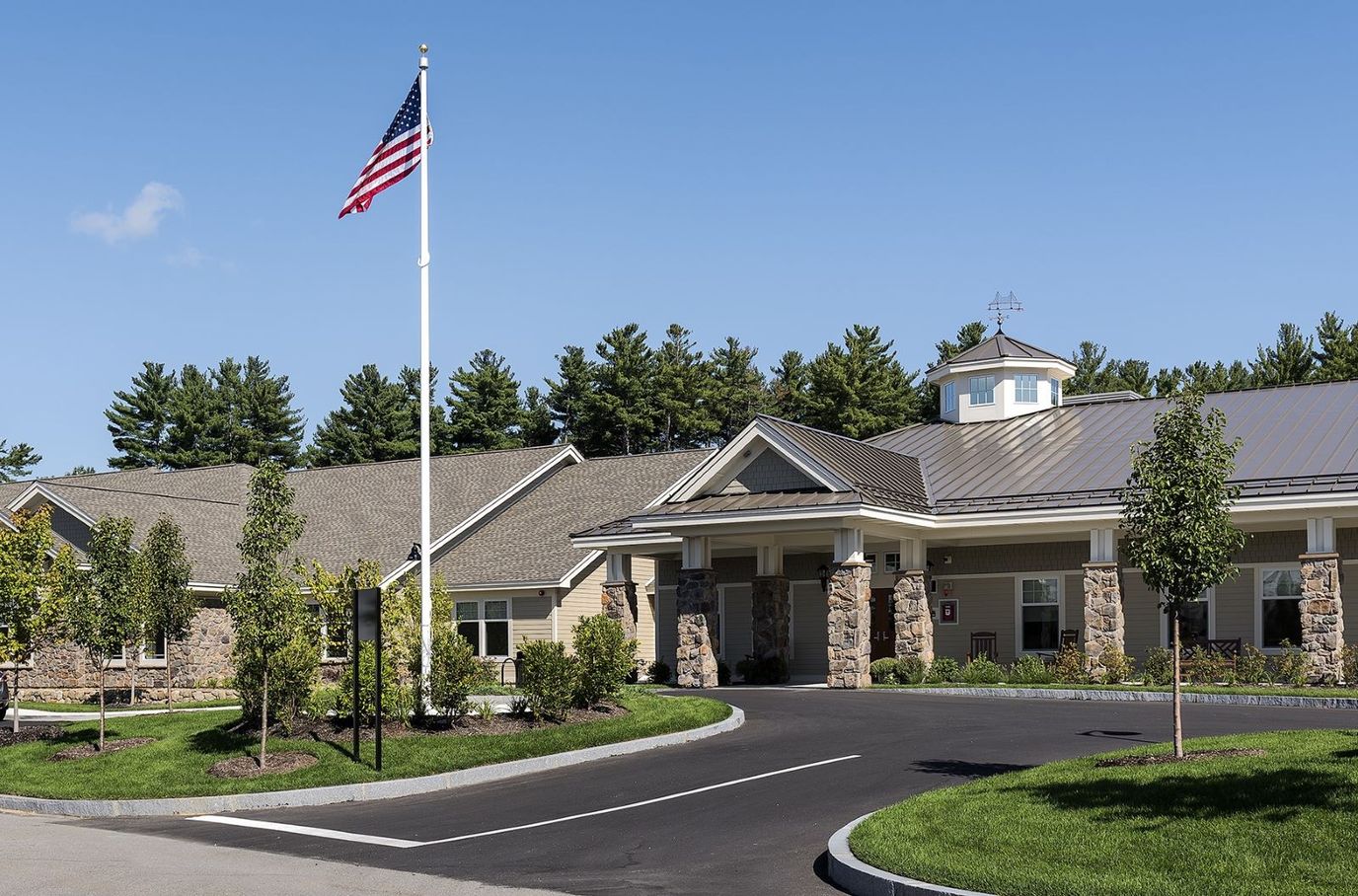 Exterior view of a senior living facility with a flag