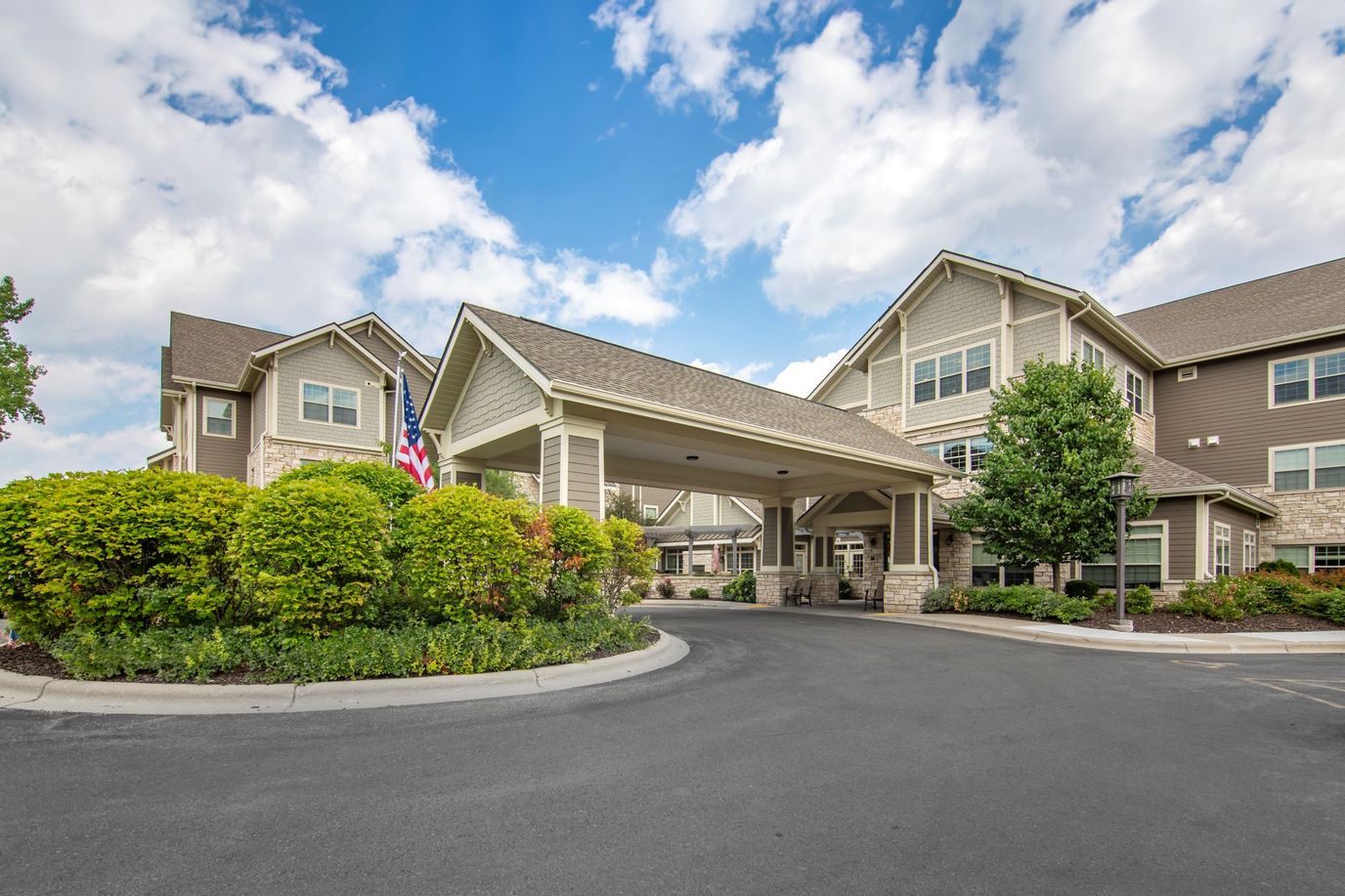 Front entrance of a senior living facility surrounded by landscaping