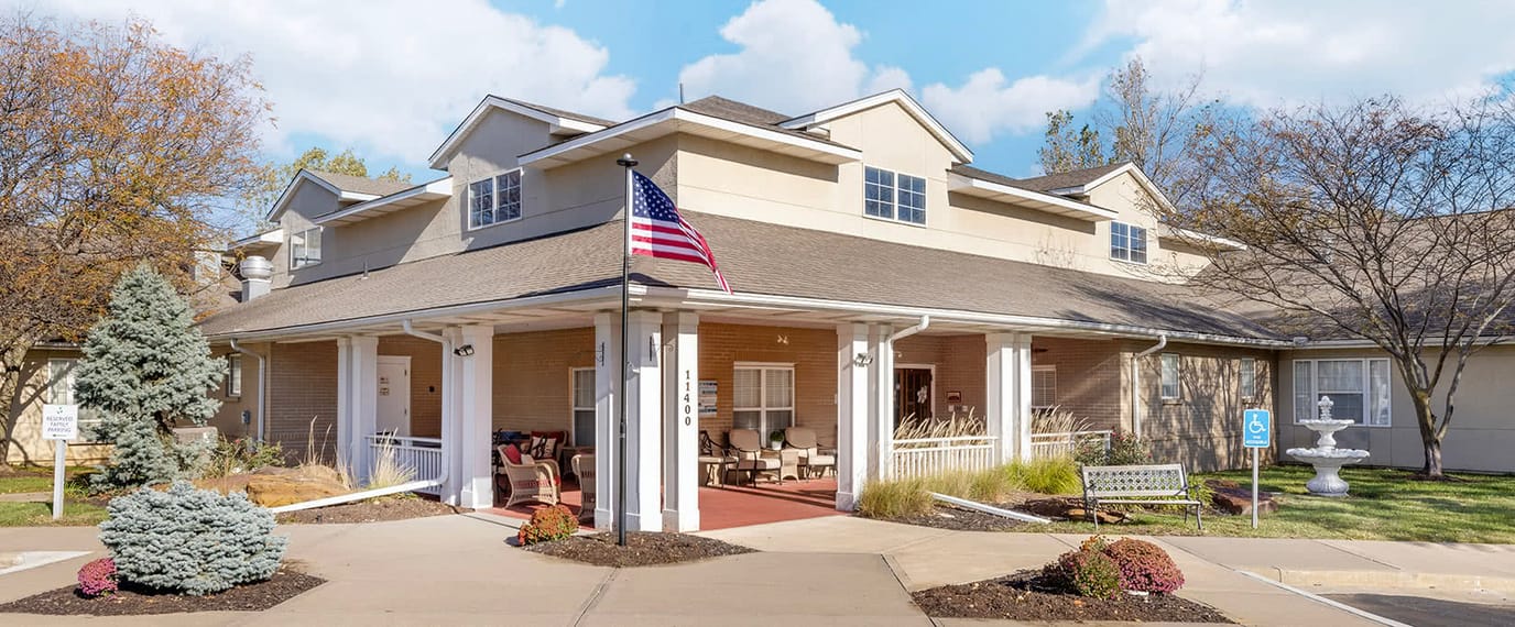 Exterior view of a senior living facility with outdoor seating