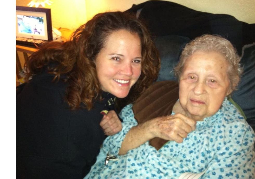 A smiling caregiver with a resident in a cozy setting