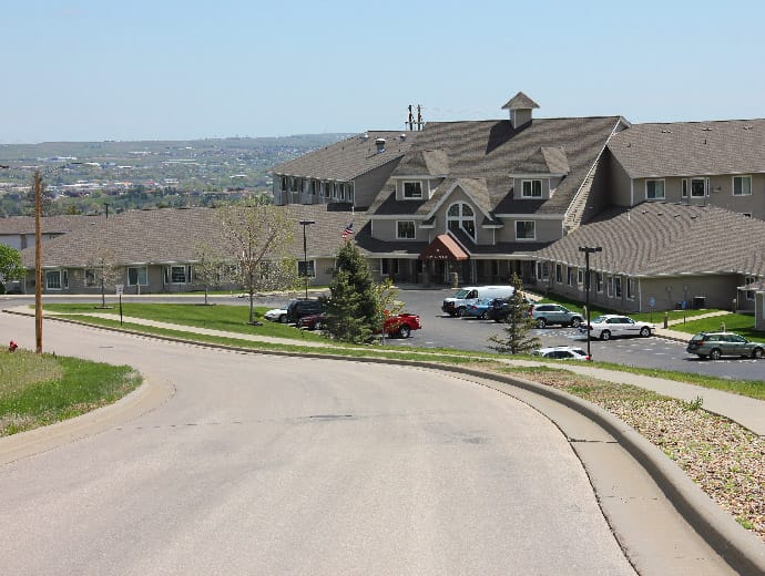 Exterior view of a senior living facility with parking