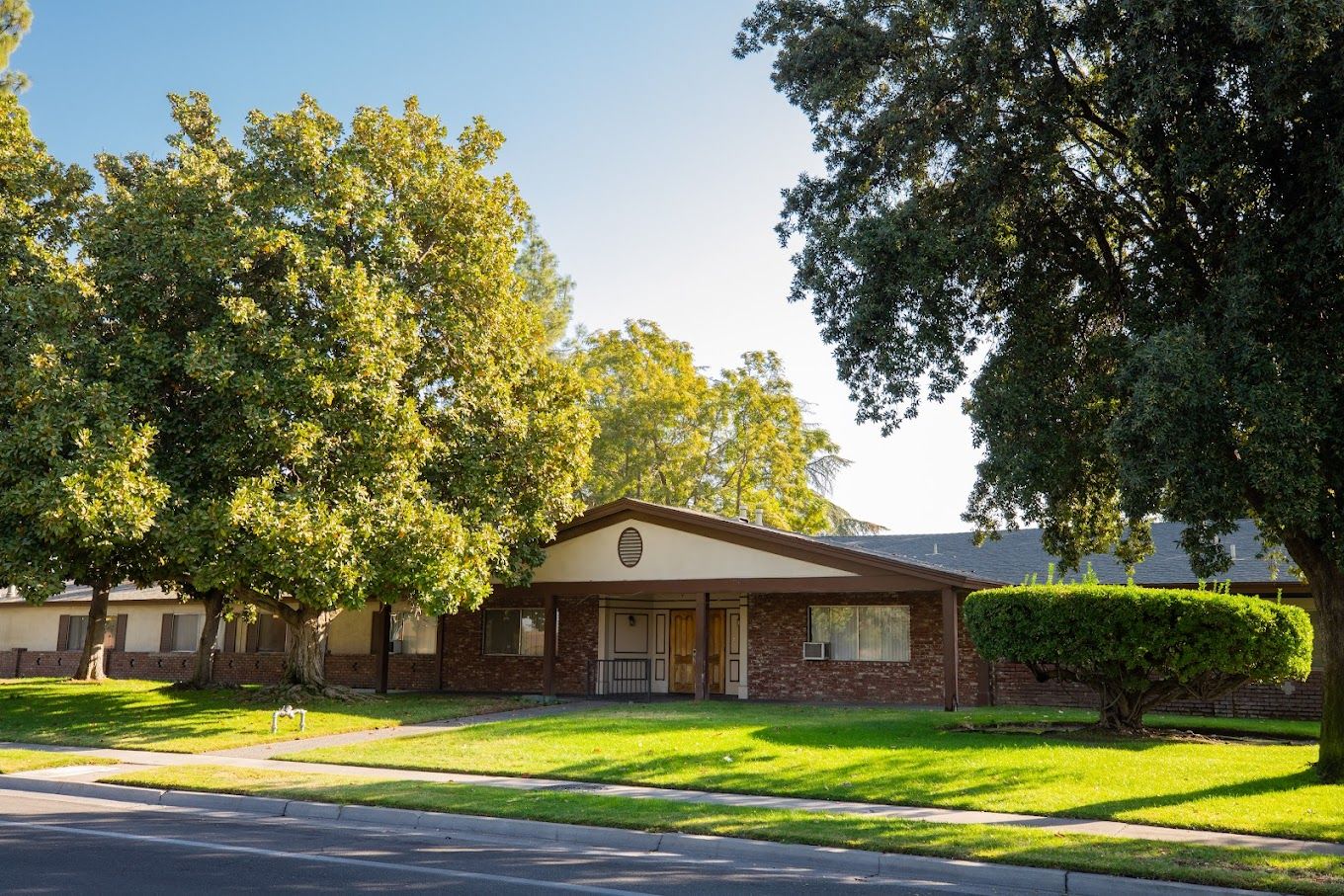Exterior view of Fresno Nursing Center with surrounding greenery