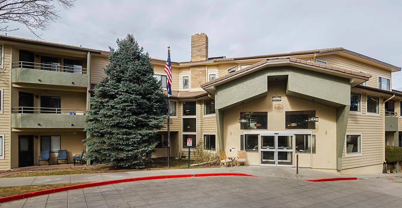 Exterior view of Lakewood Estates facility with trees and entrance