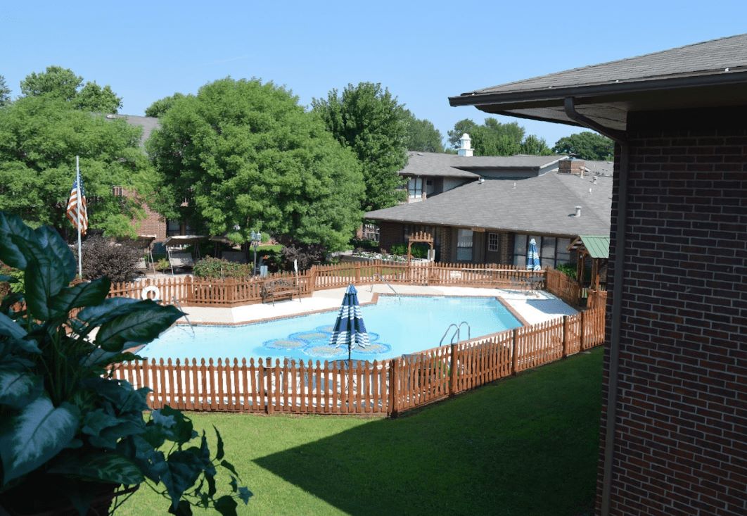 Outdoor pool area with wooden fencing and greenery