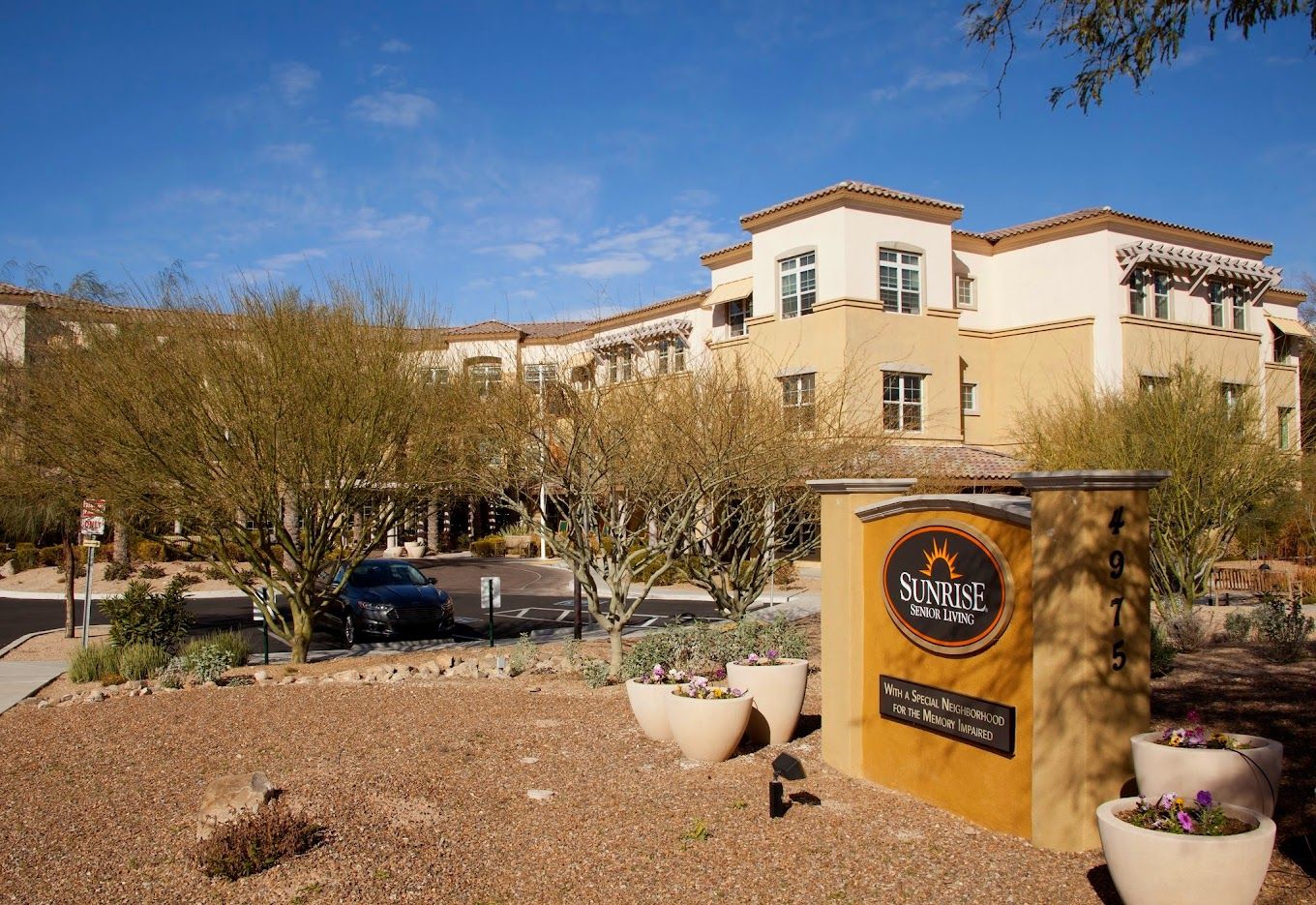 Exterior view of Sunrise at River Road with landscaping and signage